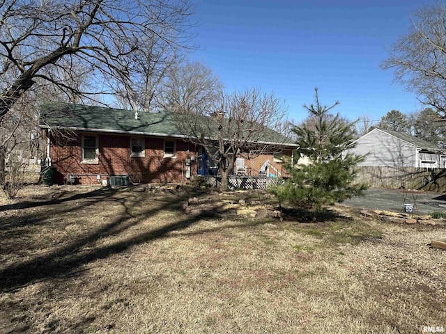 rear view of house with brick siding and fence