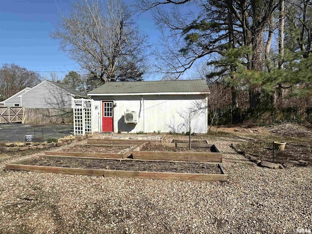 view of outdoor structure with a garden, fence, and an outdoor structure