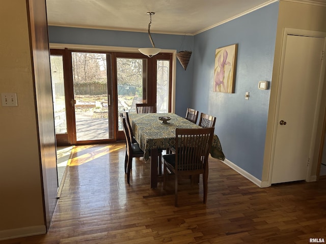 dining room featuring ornamental molding, dark wood-style flooring, and baseboards