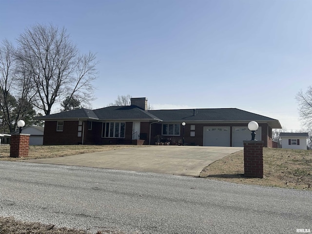 ranch-style home featuring concrete driveway, a chimney, and an attached garage