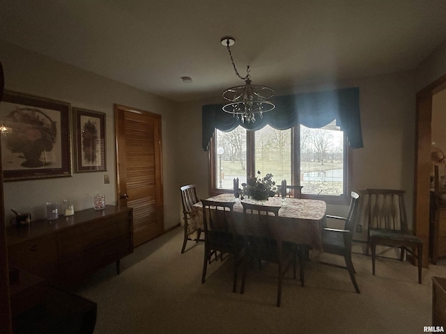 dining space with light colored carpet and a notable chandelier