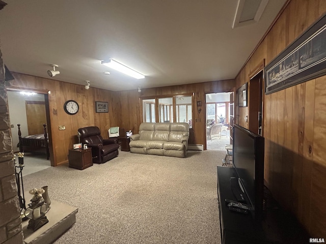 carpeted living area with a baseboard heating unit and wood walls