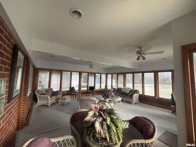 sunroom featuring a ceiling fan, visible vents, and a healthy amount of sunlight