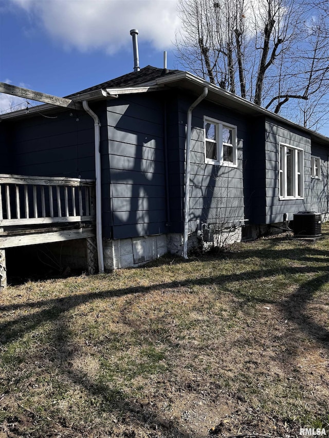 view of side of home featuring a lawn and cooling unit