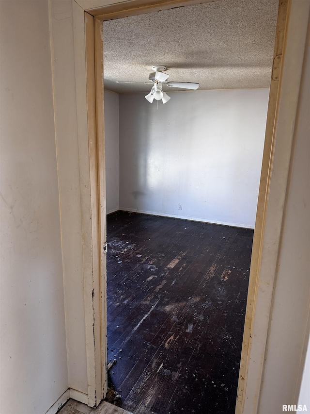 empty room featuring ceiling fan, a textured ceiling, and hardwood / wood-style flooring