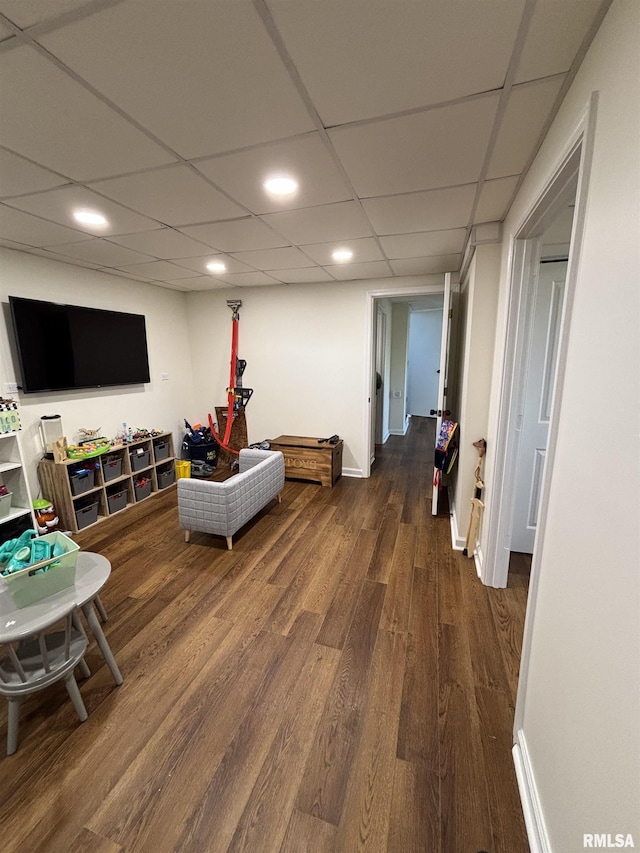 interior space featuring baseboards, a drop ceiling, wood finished floors, and recessed lighting