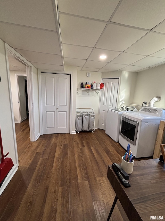 laundry room with laundry area, washing machine and dryer, dark wood-style floors, and baseboards