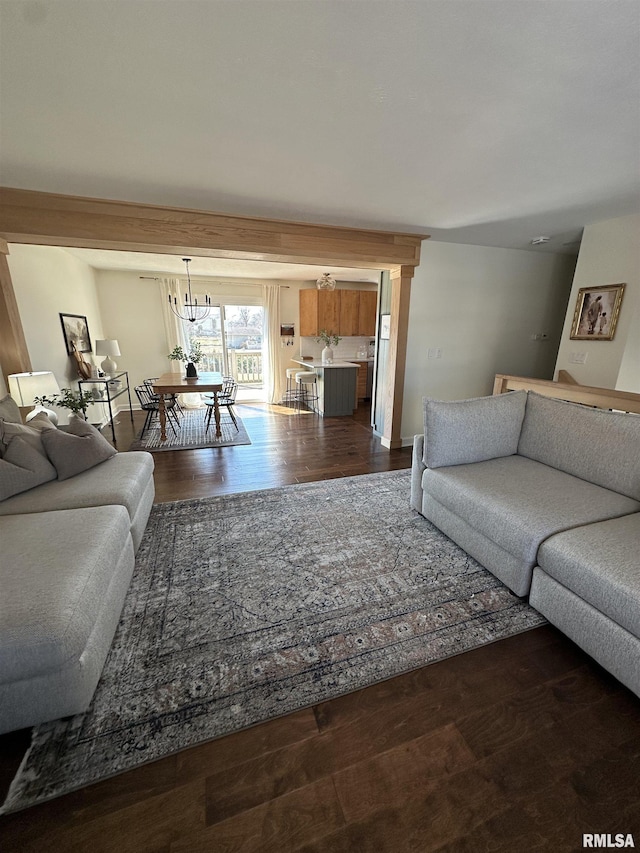 living room featuring dark wood-style floors and a notable chandelier