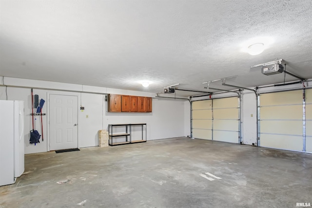 garage with freestanding refrigerator and a garage door opener