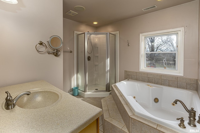 bathroom featuring a whirlpool tub, a stall shower, vanity, and visible vents