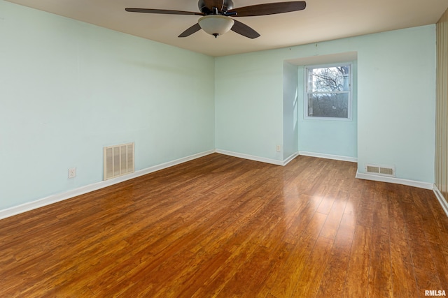 unfurnished room with wood-type flooring, visible vents, ceiling fan, and baseboards