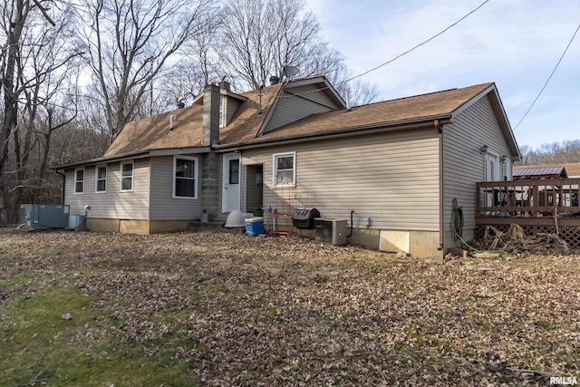 rear view of house featuring a chimney, a wooden deck, and central air condition unit