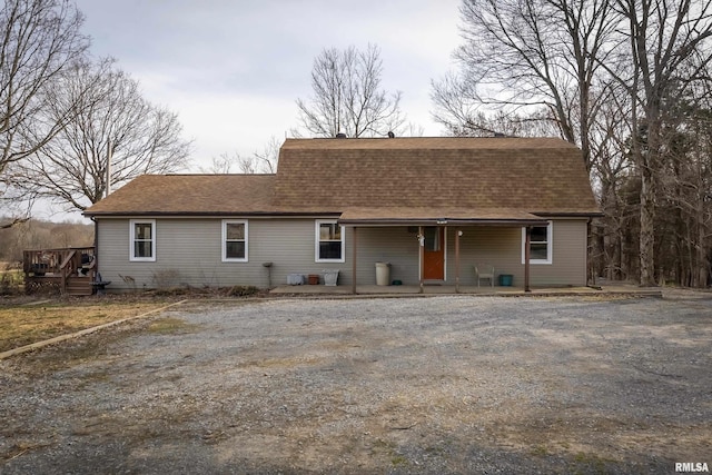 colonial inspired home featuring driveway, a shingled roof, a porch, and a gambrel roof