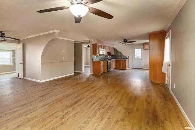 unfurnished living room with crown molding, baseboards, and wood finished floors