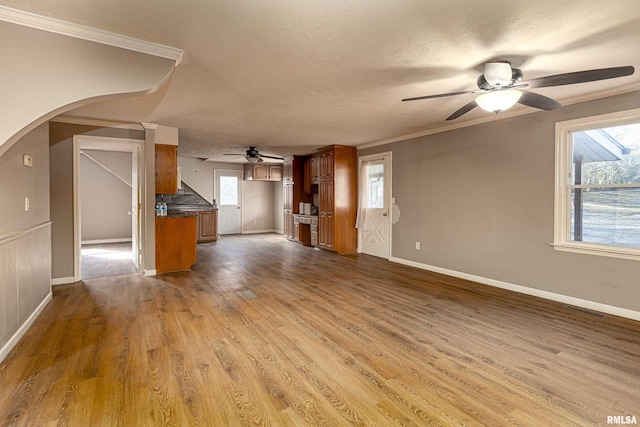 unfurnished living room featuring arched walkways, dark wood finished floors, visible vents, ornamental molding, and a textured ceiling