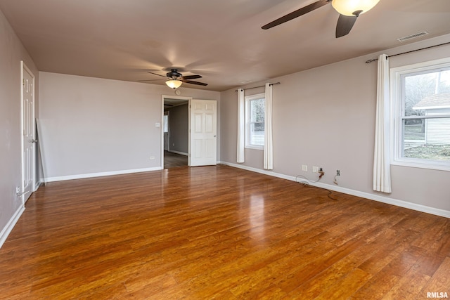 unfurnished room with baseboards, ceiling fan, visible vents, and wood finished floors