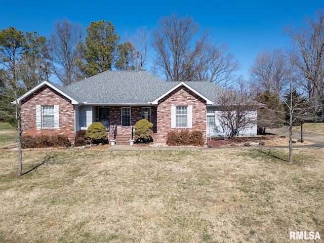 ranch-style home with brick siding, a front lawn, and roof with shingles