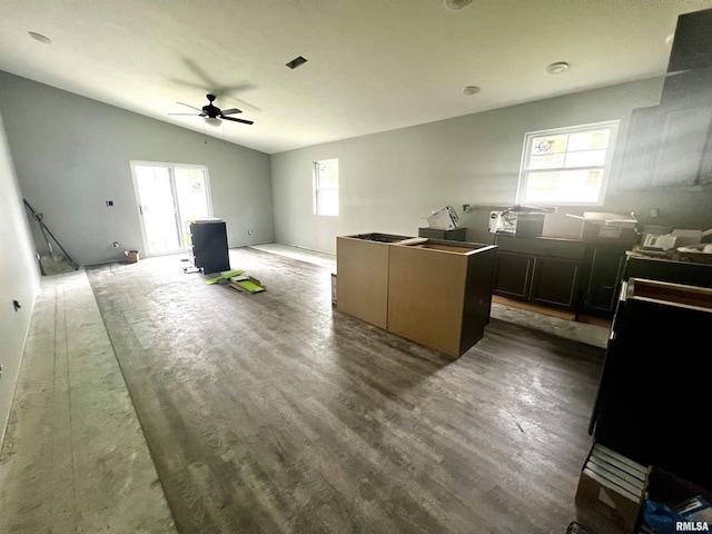 kitchen with ceiling fan, a kitchen island, wood finished floors, and vaulted ceiling