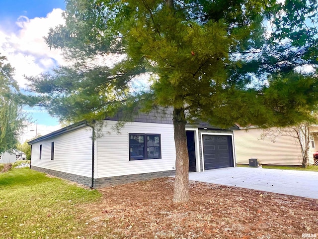 view of property exterior featuring central air condition unit, a lawn, a garage, and driveway