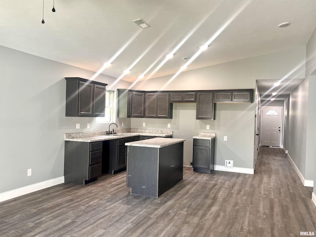 kitchen with lofted ceiling, dark wood-style floors, and a kitchen island