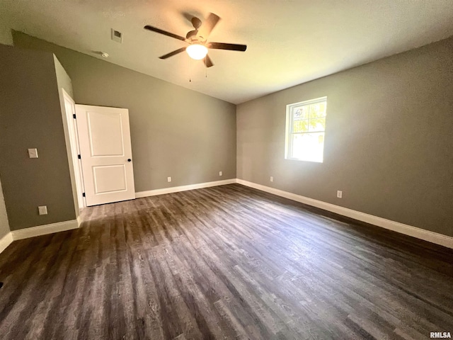 unfurnished room with visible vents, dark wood-type flooring, lofted ceiling, baseboards, and ceiling fan