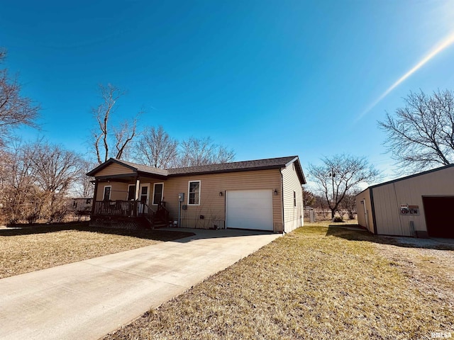 ranch-style home featuring covered porch, driveway, a front lawn, and a garage