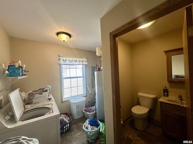 laundry area with a sink, gas water heater, a textured ceiling, and washing machine and dryer