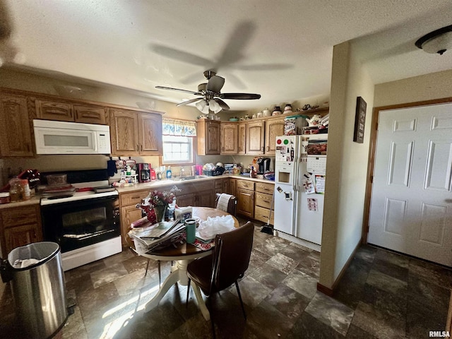 kitchen featuring stone finish flooring, white appliances, light countertops, and a sink