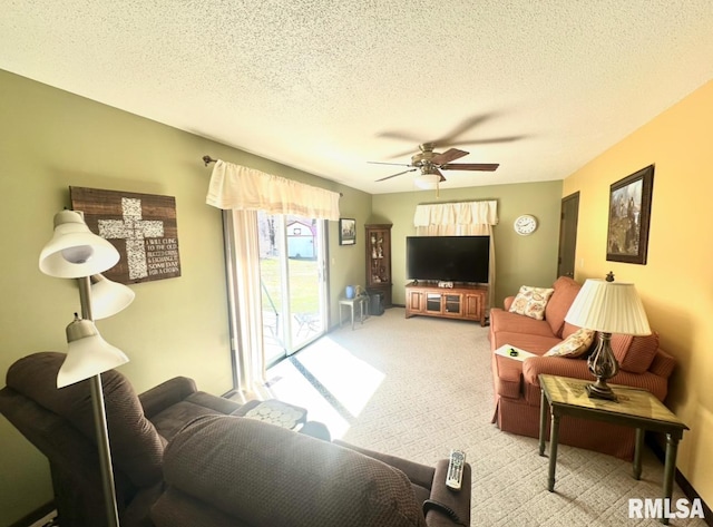 carpeted living area with a textured ceiling and ceiling fan