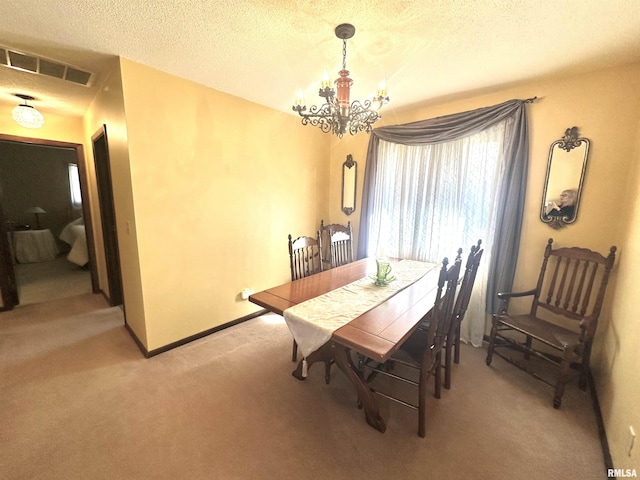 dining space with visible vents, a notable chandelier, a textured ceiling, baseboards, and light colored carpet