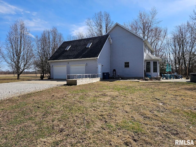 view of side of property featuring a yard, a garage, and driveway