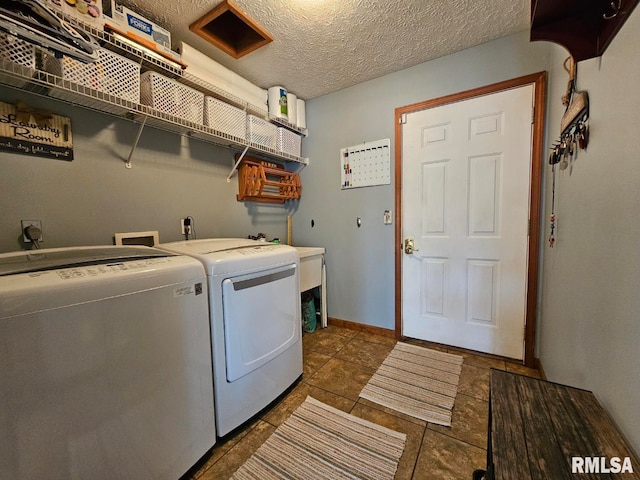 laundry room featuring washer and dryer, laundry area, baseboards, and a textured ceiling