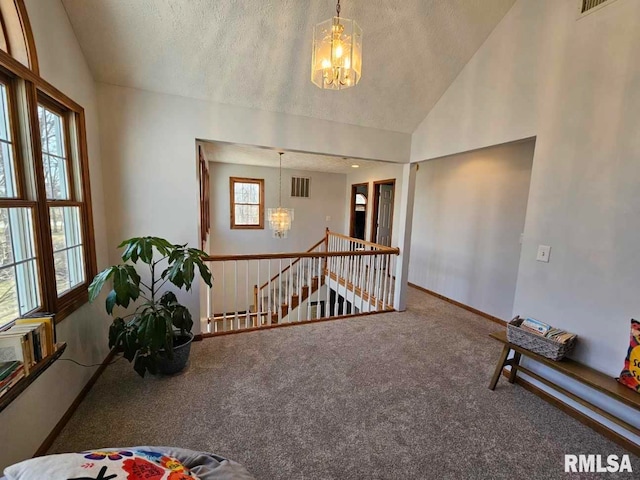 unfurnished room with visible vents, lofted ceiling, and an inviting chandelier