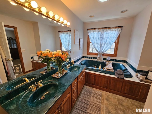 bathroom featuring a bath, tile patterned flooring, and a sink