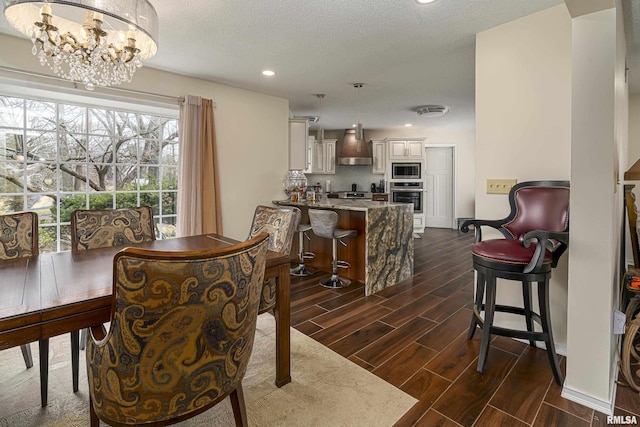 dining area featuring wood finish floors, a textured ceiling, a chandelier, and recessed lighting