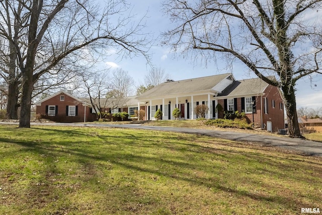 view of front of home featuring brick siding and a front lawn