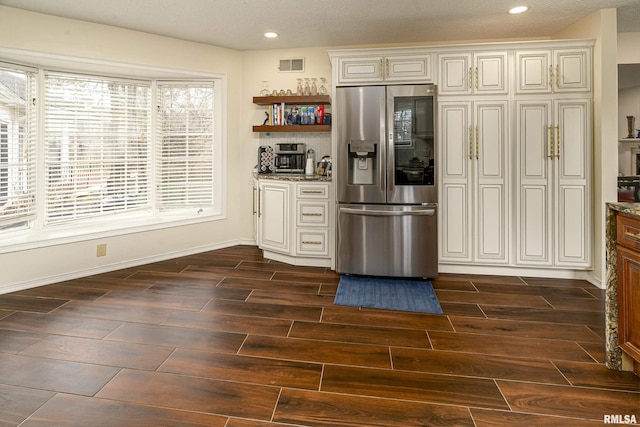 kitchen featuring visible vents, wood finish floors, open shelves, recessed lighting, and stainless steel fridge