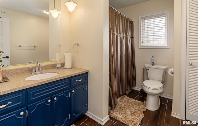 bathroom with vanity, baseboards, wood tiled floor, a closet, and toilet