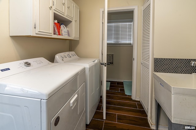 laundry area with baseboards, cabinet space, independent washer and dryer, and wood finish floors