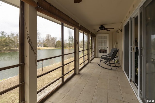 sunroom / solarium with a water view and a ceiling fan