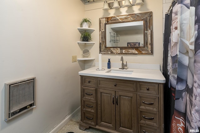 bathroom featuring vanity, heating unit, and baseboards