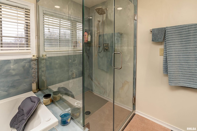 bathroom with a stall shower and a garden tub