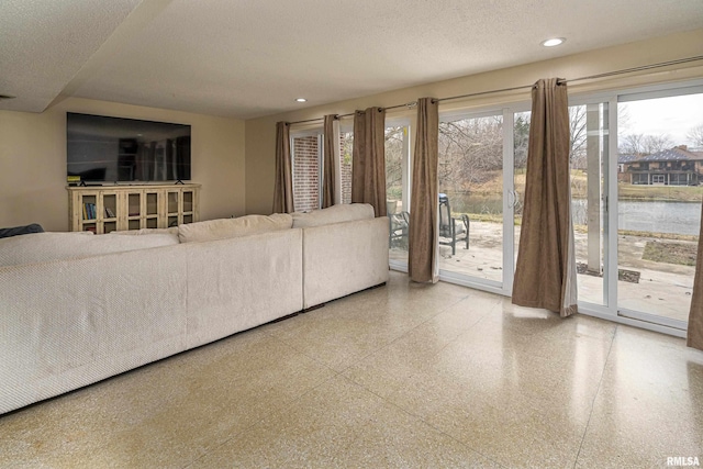 unfurnished living room featuring recessed lighting, speckled floor, and a textured ceiling