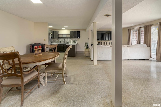 dining room featuring light speckled floor, visible vents, and a textured ceiling