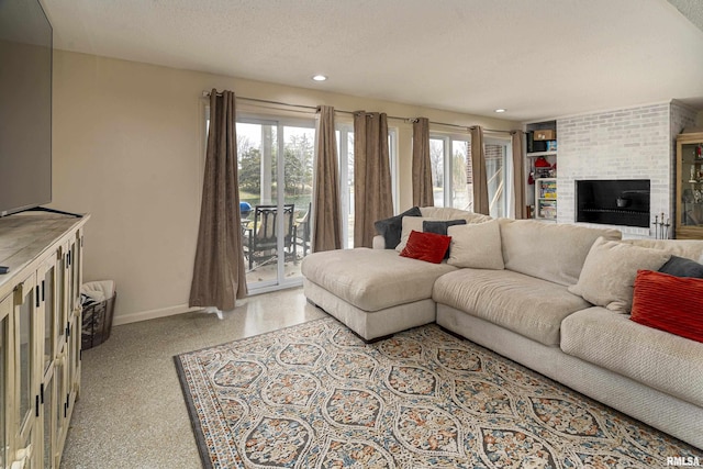 living room with a textured ceiling, recessed lighting, speckled floor, baseboards, and a brick fireplace