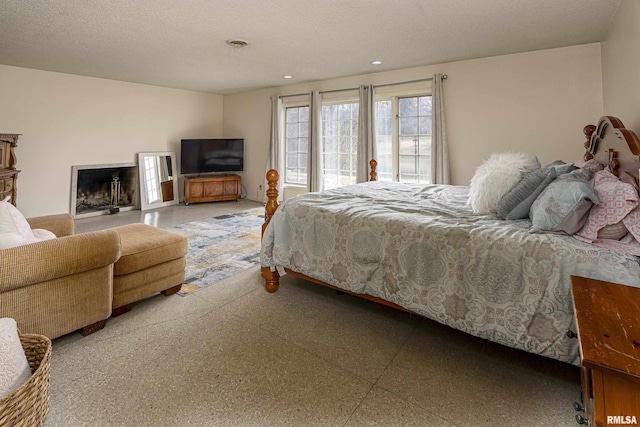 bedroom with recessed lighting, visible vents, a textured ceiling, and a fireplace