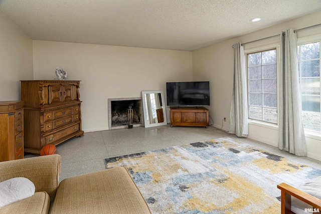 living room with recessed lighting, a fireplace, baseboards, and a textured ceiling