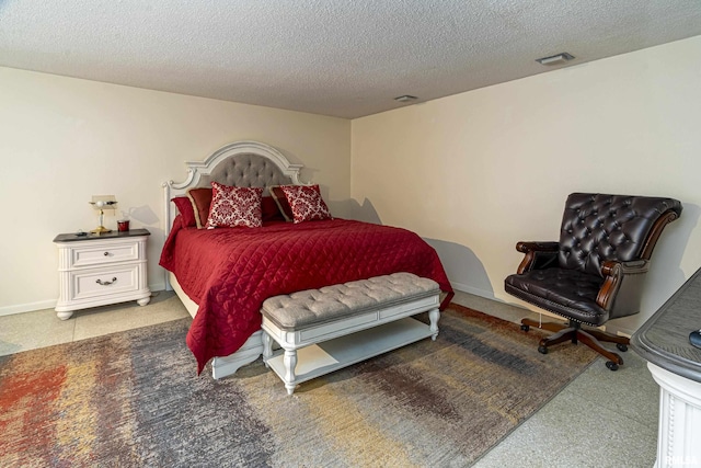 bedroom featuring baseboards, visible vents, and a textured ceiling