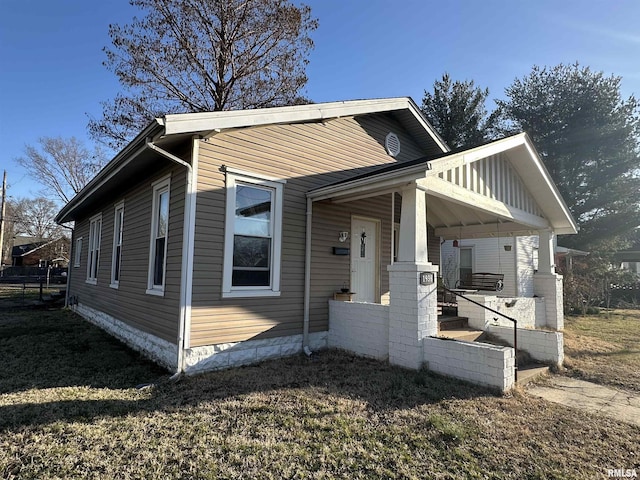 view of front of house with covered porch and a front lawn