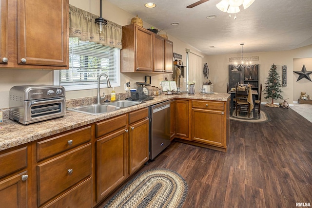 kitchen featuring brown cabinetry, a peninsula, a toaster, a sink, and dishwasher